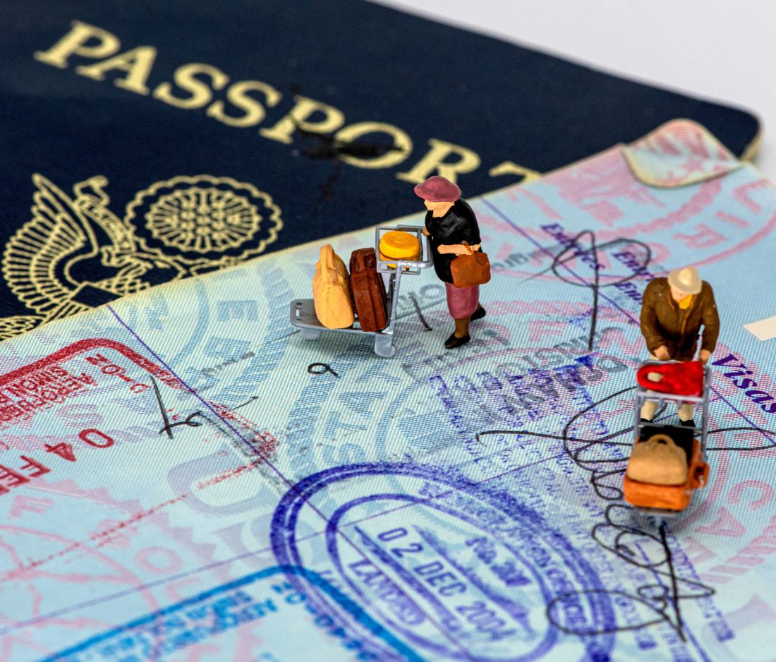 Passports with visa stamps and miniature travellers